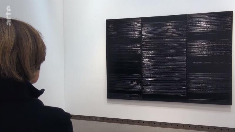 Jean-Michel Basquiat dans son atelier, entouré de ses œuvres, reflétant son processus créatif et son influence sur l’art contemporain et la culture Basquiat Madonna